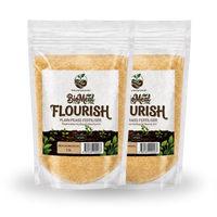 Two stand-up pouches of BioMeal Flourish plant fertilizer, showing the light brown granular contents through clear packaging, on a white background.